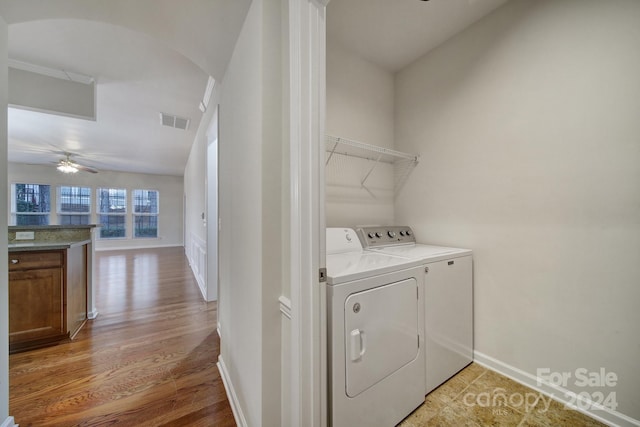 laundry room with wood-type flooring, washer and clothes dryer, and ceiling fan