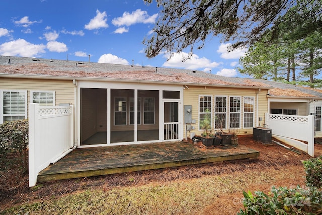 rear view of property featuring a sunroom and central AC