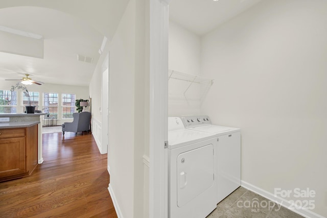 washroom with visible vents, laundry area, light wood-style flooring, ceiling fan, and washer and clothes dryer