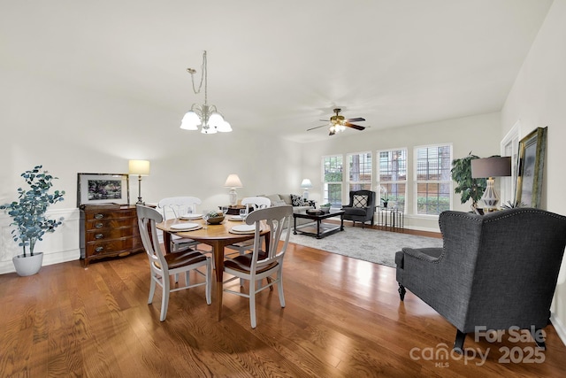 dining area featuring ceiling fan with notable chandelier and wood finished floors