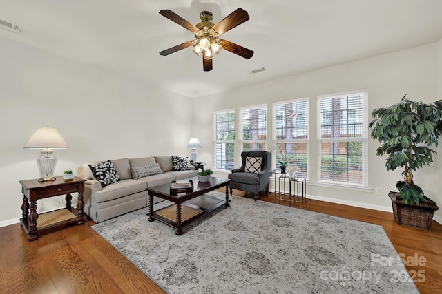 living room with visible vents, a ceiling fan, baseboards, and wood finished floors