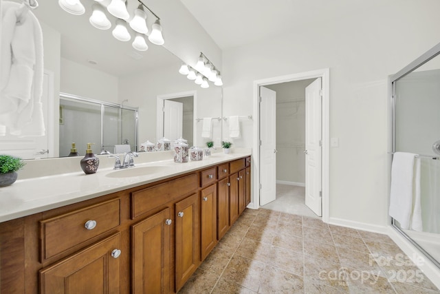 bathroom featuring double vanity, tile patterned floors, a stall shower, and a sink