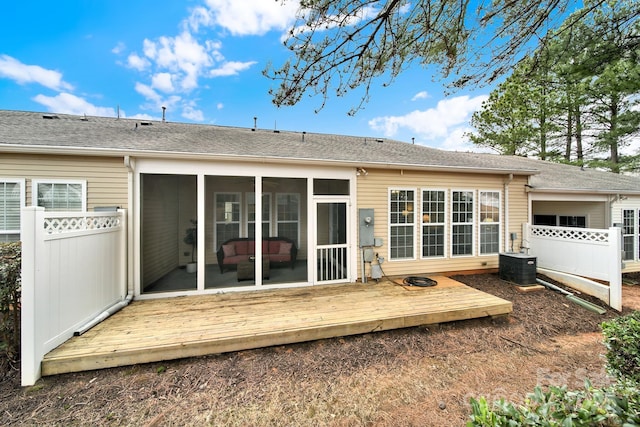 back of house featuring fence, central air condition unit, a wooden deck, roof with shingles, and a sunroom