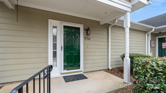 entrance to property with a shingled roof