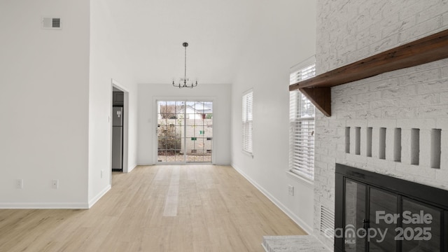 interior space featuring light wood-style floors, visible vents, baseboards, and an inviting chandelier