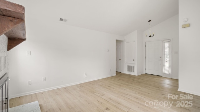 unfurnished living room featuring light wood-type flooring, visible vents, and a notable chandelier