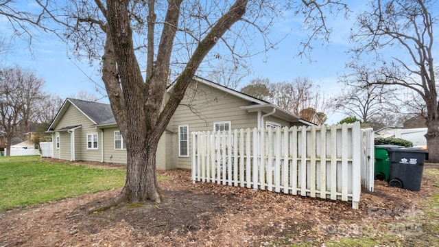 view of property exterior with a yard and fence