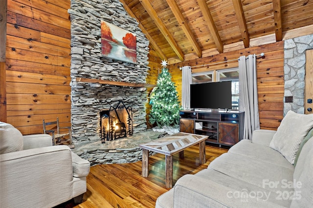 living room featuring wood walls, hardwood / wood-style flooring, a fireplace, beamed ceiling, and wood ceiling