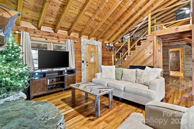 living room featuring beamed ceiling, wood walls, wood ceiling, and hardwood / wood-style floors