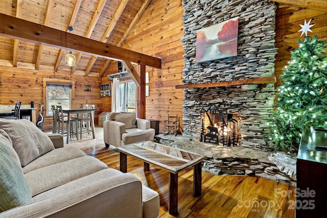 unfurnished living room featuring hardwood / wood-style flooring, lofted ceiling with beams, wood ceiling, and a fireplace