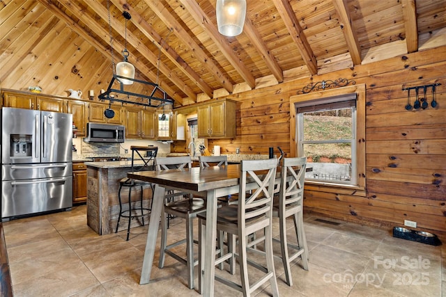 dining space with beamed ceiling, wooden walls, wood ceiling, and high vaulted ceiling