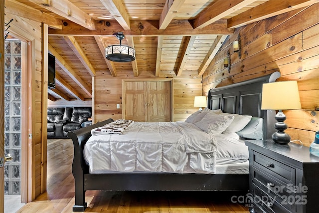 bedroom featuring vaulted ceiling with beams, wood walls, hardwood / wood-style floors, and wooden ceiling