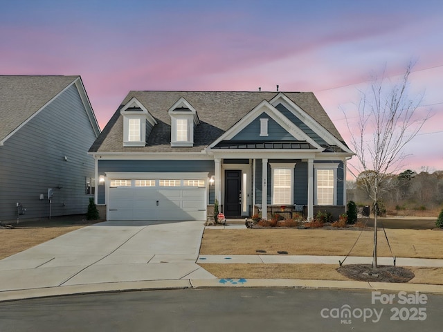 view of front of home with a garage, driveway, roof with shingles, and covered porch