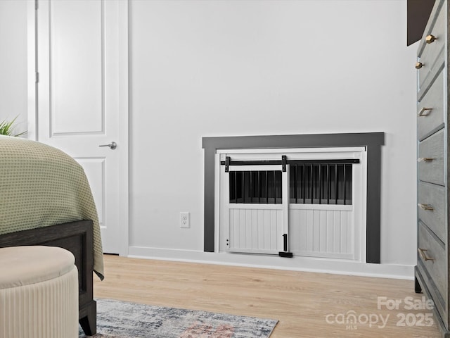 bedroom featuring light wood-type flooring and baseboards