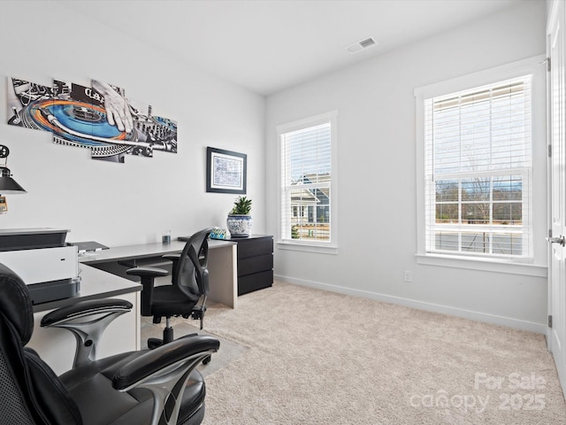 office space with light carpet, visible vents, and baseboards