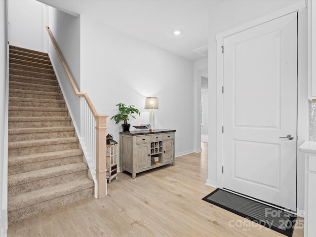 foyer featuring light wood-style floors, recessed lighting, baseboards, and stairs