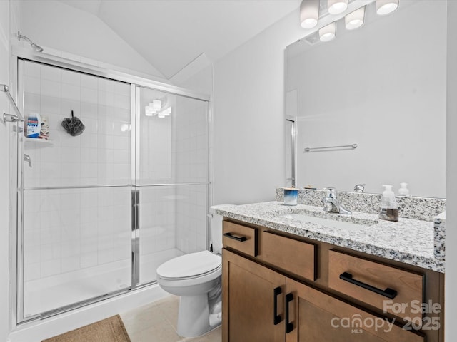 bathroom with toilet, a stall shower, vaulted ceiling, vanity, and tile patterned floors