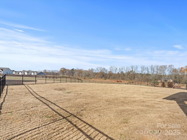 view of yard with fence and a rural view