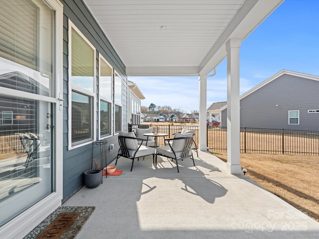 view of patio featuring a residential view and fence