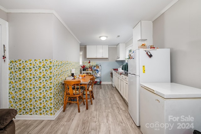 kitchen with white cabinets, white refrigerator, ornamental molding, and light hardwood / wood-style flooring