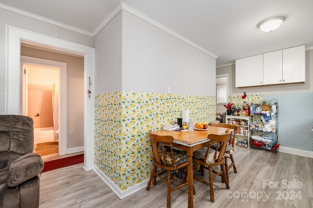 dining space with crown molding and light wood-type flooring