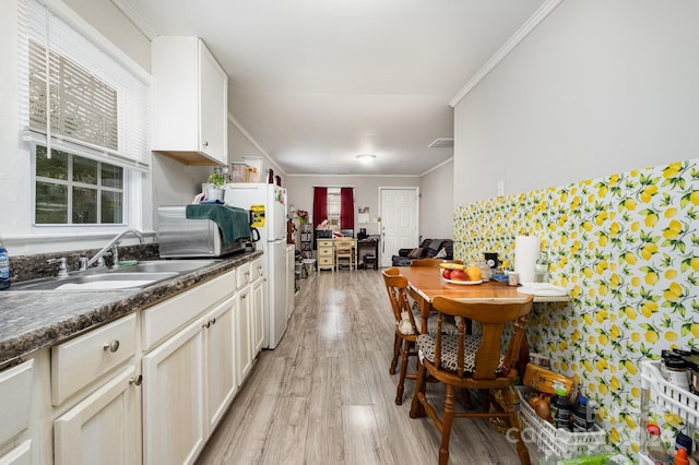 kitchen featuring light wood-type flooring, white refrigerator, ornamental molding, and sink