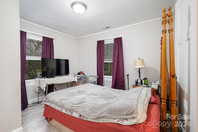 bedroom featuring ornamental molding and light hardwood / wood-style flooring