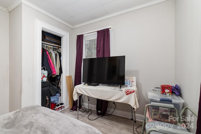 bedroom featuring light wood-type flooring, a closet, and ornamental molding