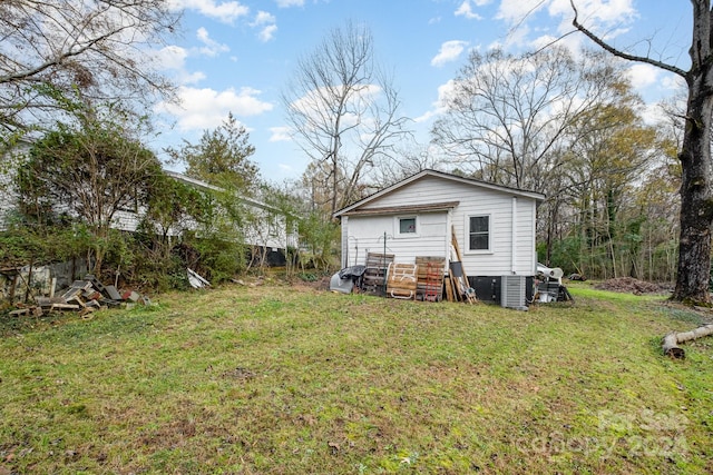 back of property with a yard and central air condition unit