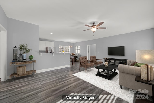 living room featuring dark hardwood / wood-style floors and ceiling fan with notable chandelier