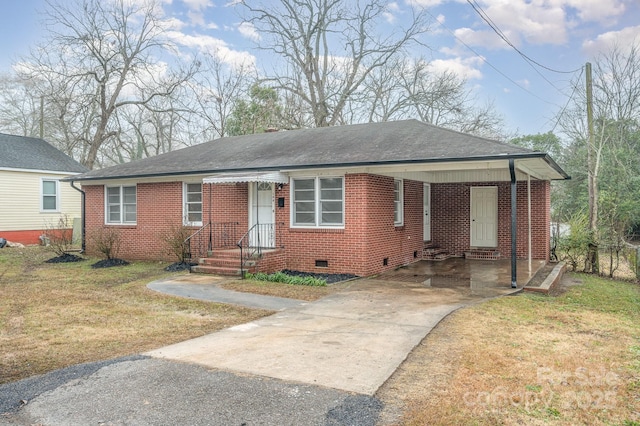 ranch-style home featuring driveway, crawl space, a front lawn, a carport, and brick siding