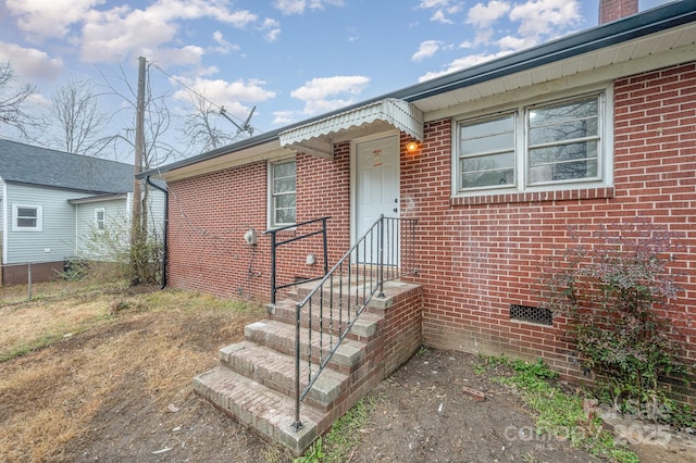 view of front facade with crawl space and brick siding