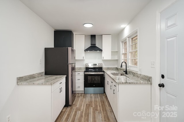 kitchen with wall chimney exhaust hood, appliances with stainless steel finishes, light wood-type flooring, open shelves, and a sink