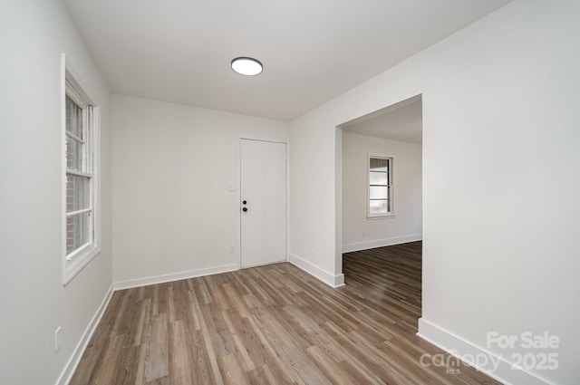 empty room featuring wood finished floors and baseboards