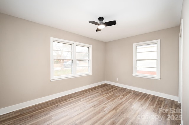 spare room with ceiling fan, baseboards, and wood finished floors