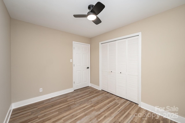 unfurnished bedroom featuring a ceiling fan, a closet, baseboards, and light wood finished floors