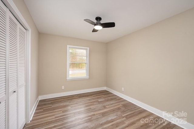 unfurnished bedroom featuring light wood finished floors, ceiling fan, baseboards, and a closet