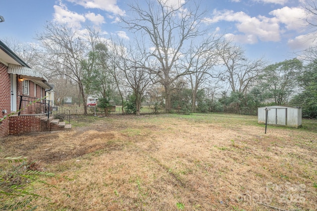 view of yard featuring an outbuilding, fence, and a storage unit