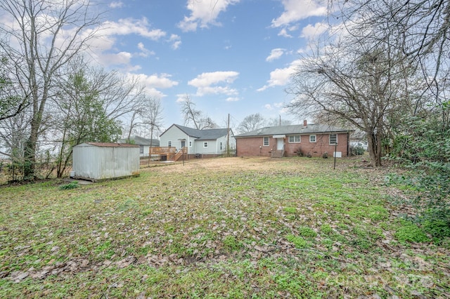 view of yard with an outdoor structure, a storage shed, and fence