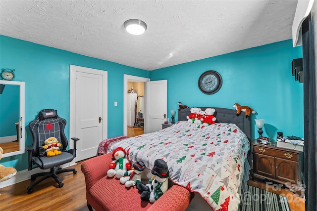 bedroom featuring wood-type flooring and a textured ceiling