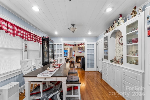 dining area with wood-type flooring, crown molding, wood ceiling, and french doors