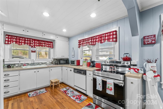 kitchen with white cabinetry, sink, stainless steel appliances, light wood-type flooring, and ornamental molding