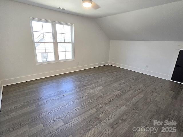 bonus room with dark wood-type flooring and vaulted ceiling