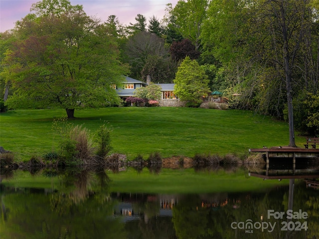 view of home's community with a lawn and a water view