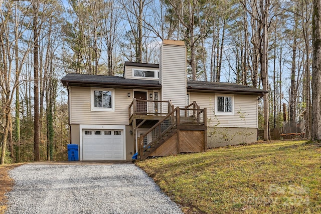 view of front facade featuring a front yard, a garage, and a wooden deck