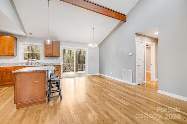 kitchen featuring decorative light fixtures, a center island, and light hardwood / wood-style flooring