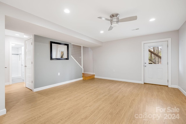 basement featuring light hardwood / wood-style floors and ceiling fan