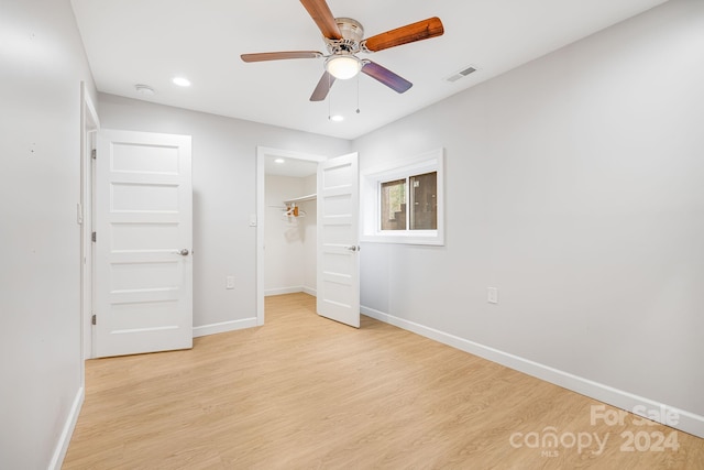 unfurnished bedroom with ceiling fan, a closet, and light hardwood / wood-style flooring