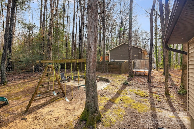 view of yard with a trampoline and a playground