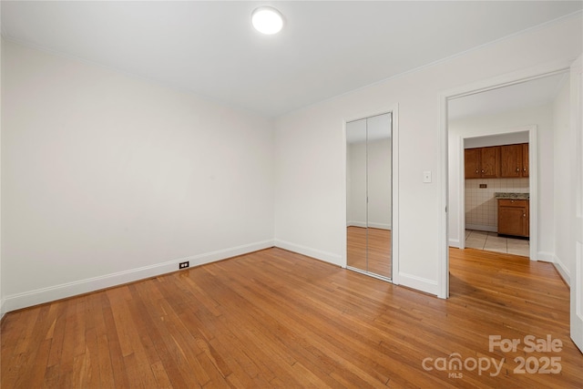 unfurnished bedroom featuring light wood-type flooring and a closet